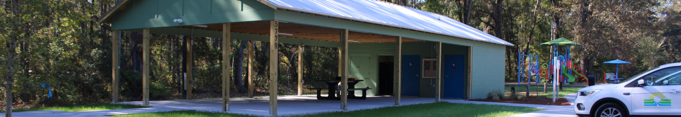 View of the covered outdoor shelter, playground and parking area at Wiltown Community Center.