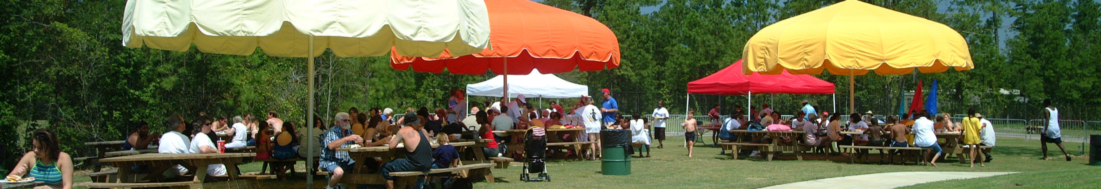 A group enjoying the picnic tables and funbrellas at Luau Landing.
