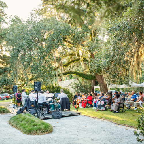 People watching the Charleston Symphony under oaks and moss